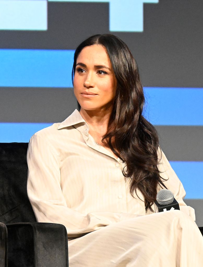 Meghan Markle on stage in white shirt