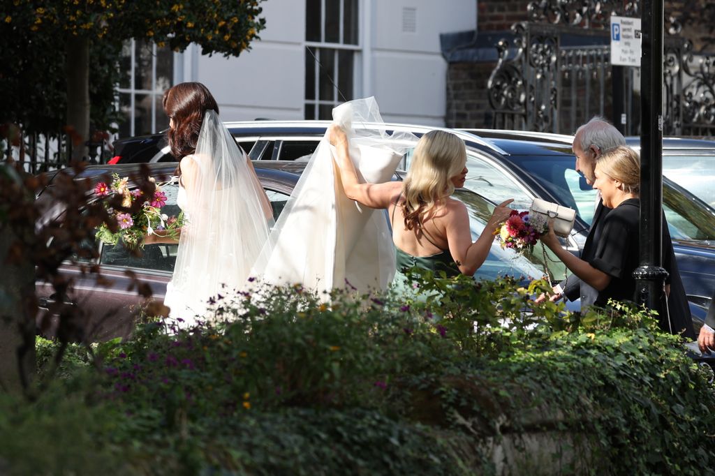 Michelle Dockery in a bridal dress as co-star Laura Carmicheal appeared to be her bridesmaid