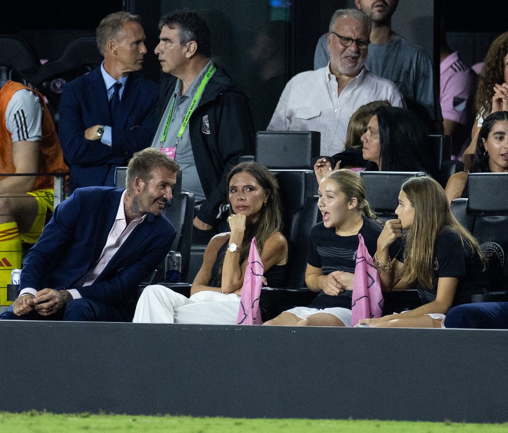 David Beckham leans in as Victoria and Harper watch the game