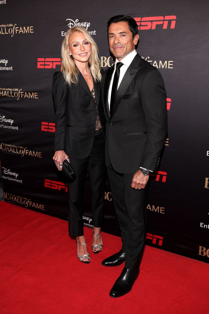 Kelly Ripa in black suit and lace top and Mark Consuelos in black suit on red carpet