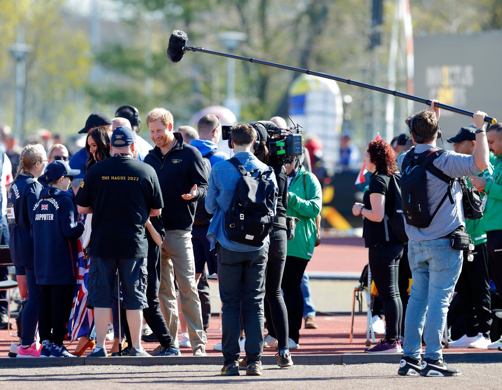 Prince Harry and Meghan Markle being filmed by a Netflix crew