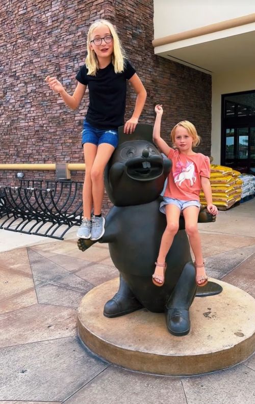 Anna Caldwell's two daugters sit on the Buccees statue 