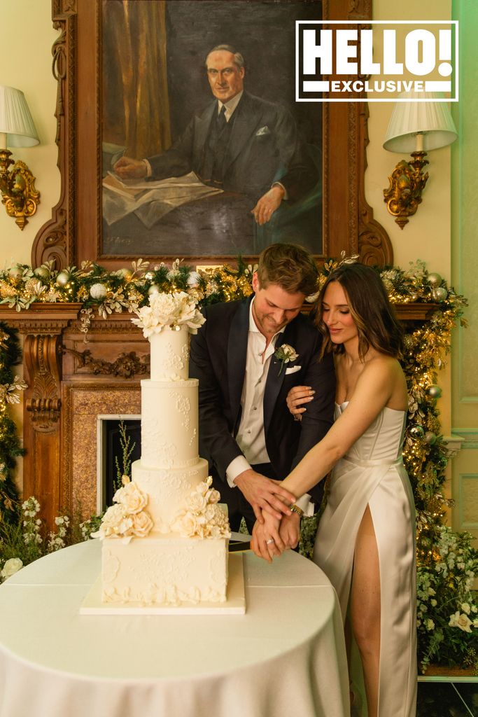 Maeva D'Ascanio and husband James Taylor cutting wedding cake with bride wearing thigh split strapless dress
