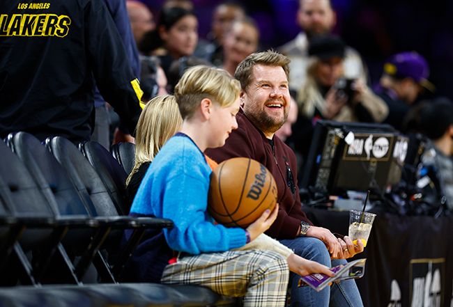 Young boy holding a basketball while sat with James Corden
