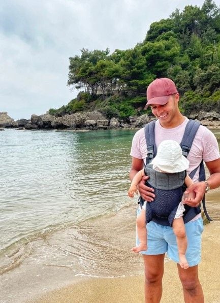 Repair Shop star Will Kirk carrying baby daughter standing on beach