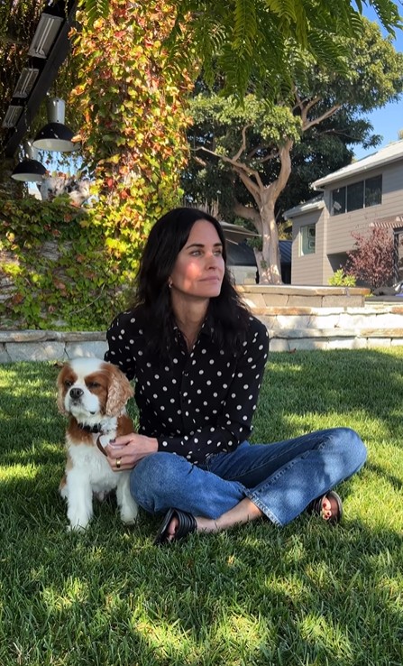 Courteney sitting on grass with dog