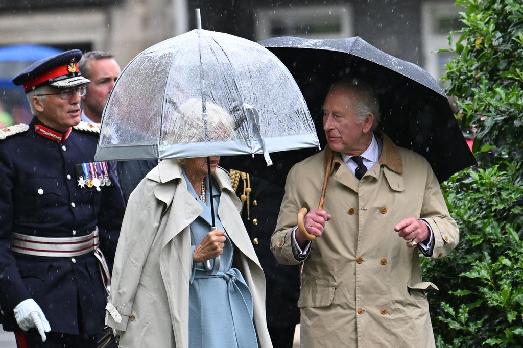 king charles and queen camilla shelter from the rain during Scotland visit 