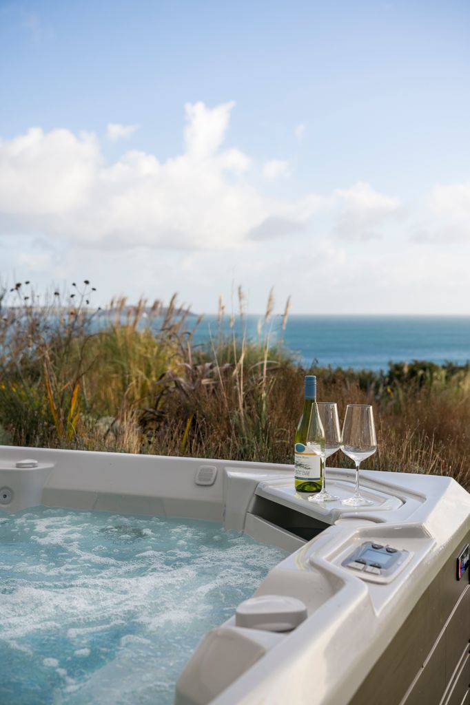 Hot tub with wine glasses and a sea view