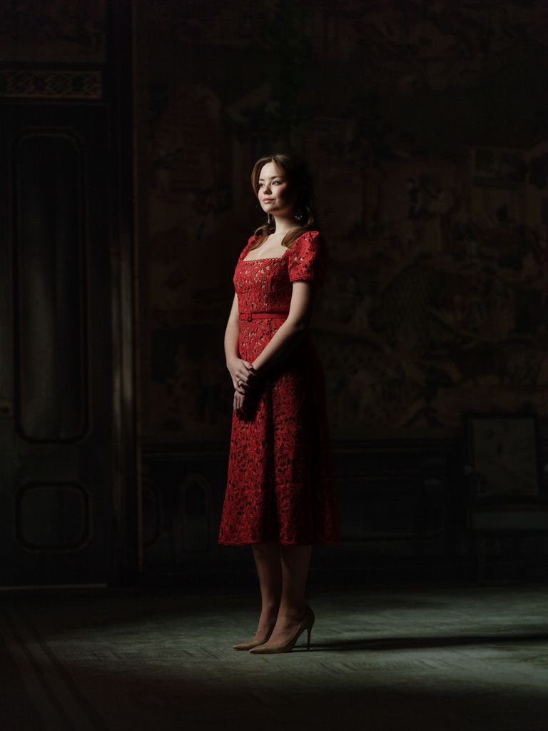 Princess Adriane posing in red dress in palace