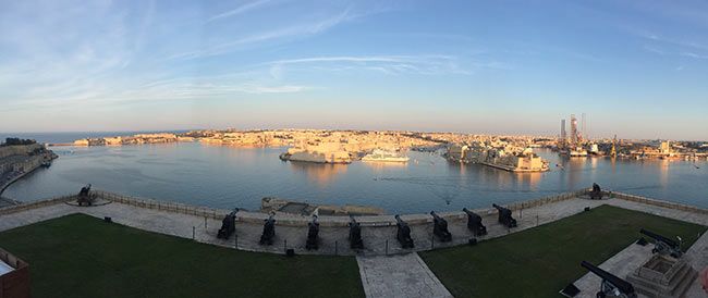 The rosy glow of the harbour in Valletta at dusk