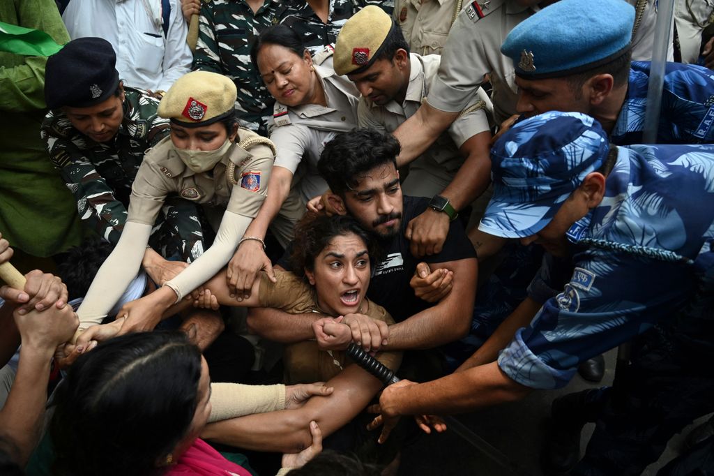 TOPSHOT - Indian wrestlers Vinesh Phogat (C) with others are detained by the police while attempting to march to India's new parliament, just as it was being inaugurated by Prime Minister Narendra Modi, during a protest against Brij Bhushan Singh, the wrestling federation chief, over allegations of sexual harassment and intimidation, in New Delhi on May 28, 2023