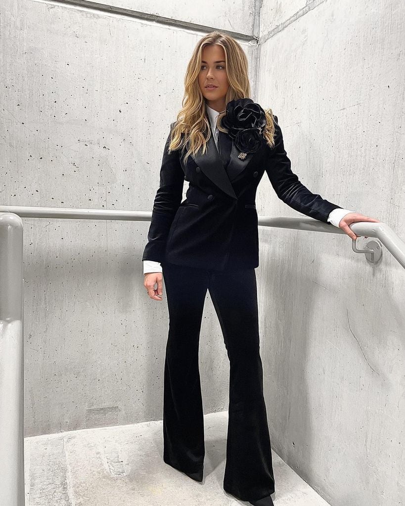 Gemma Atkinson posing on a staircase wearing a black suite 
