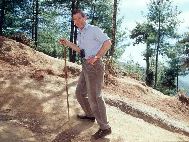 king charles as a young man hiking in a polo shirt with binoculars round his neck