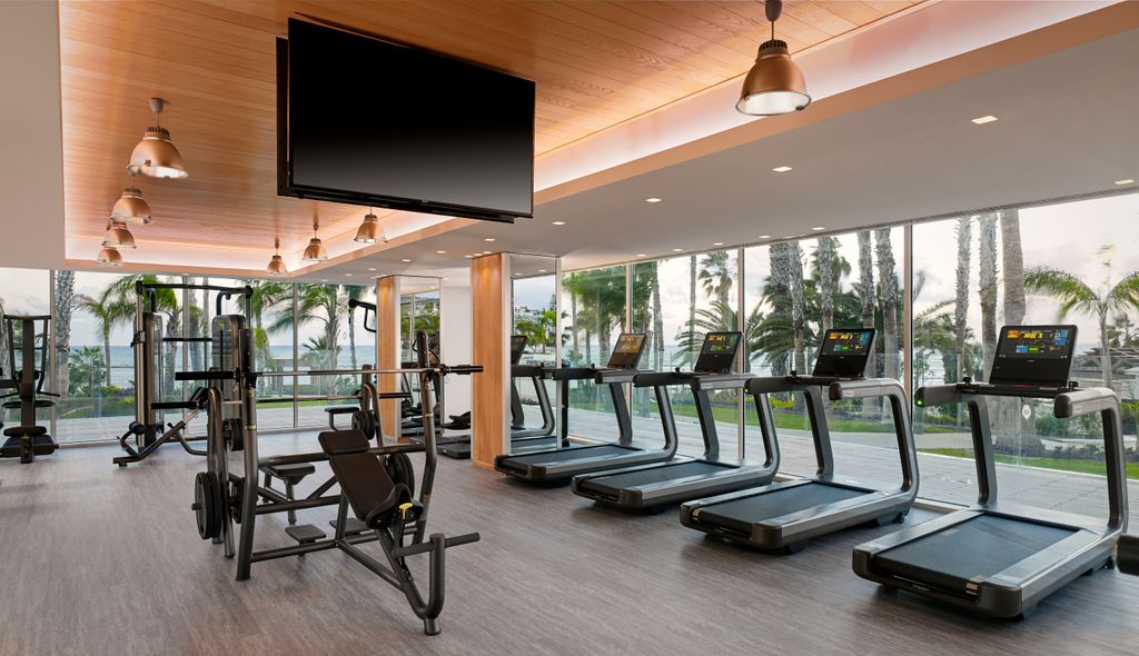 Gym with four running machines and a tv in the centre of the room