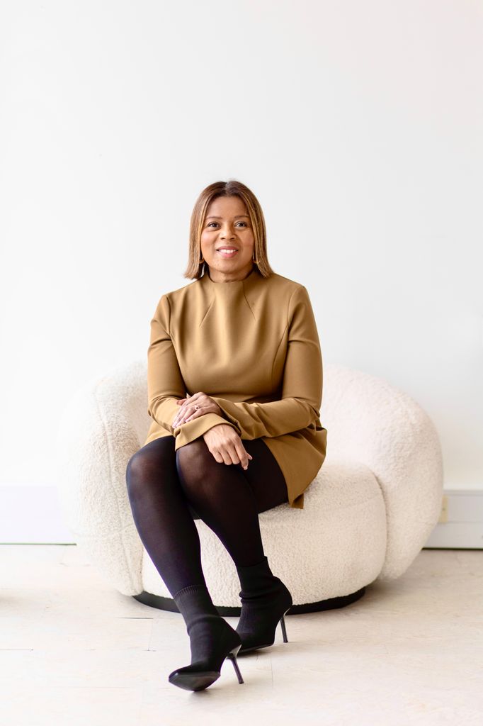 woman wearing a dress sitting on a plush chair with high heels 
