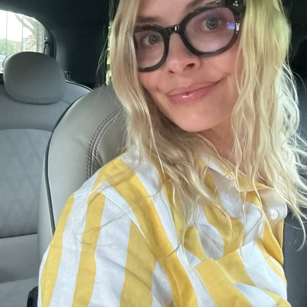 Holly Willoughby in glasses and a striped shirt in the car