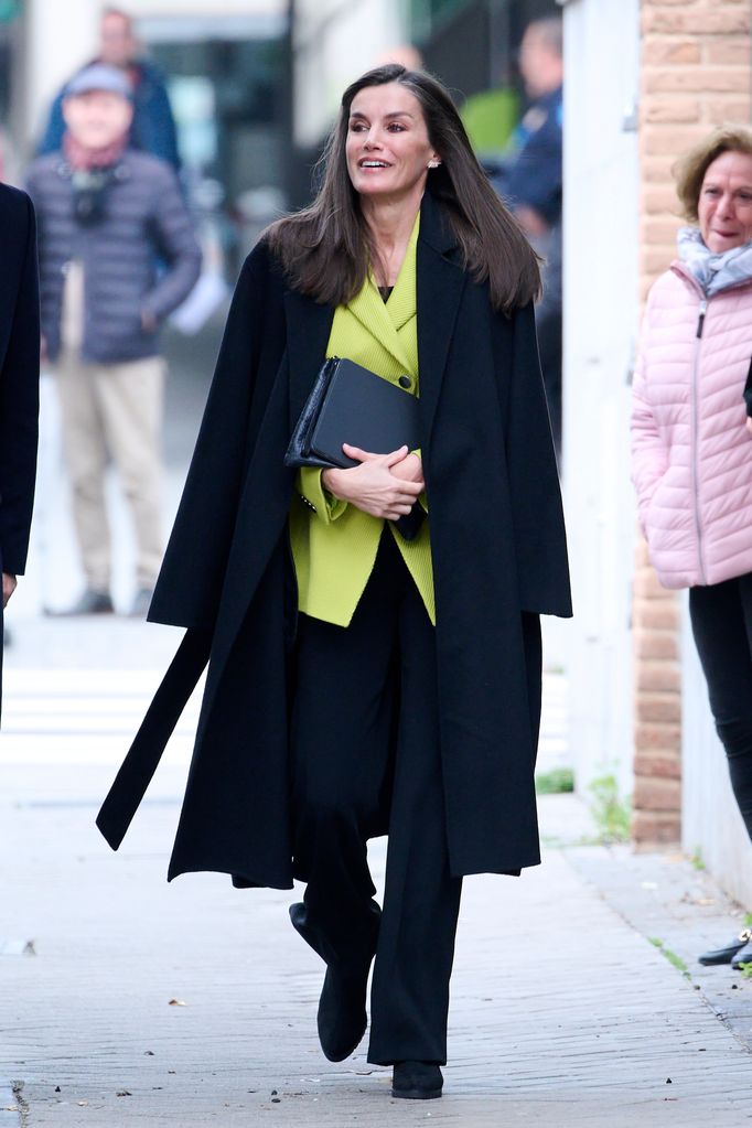 Letizia walking in black look with lime blazer