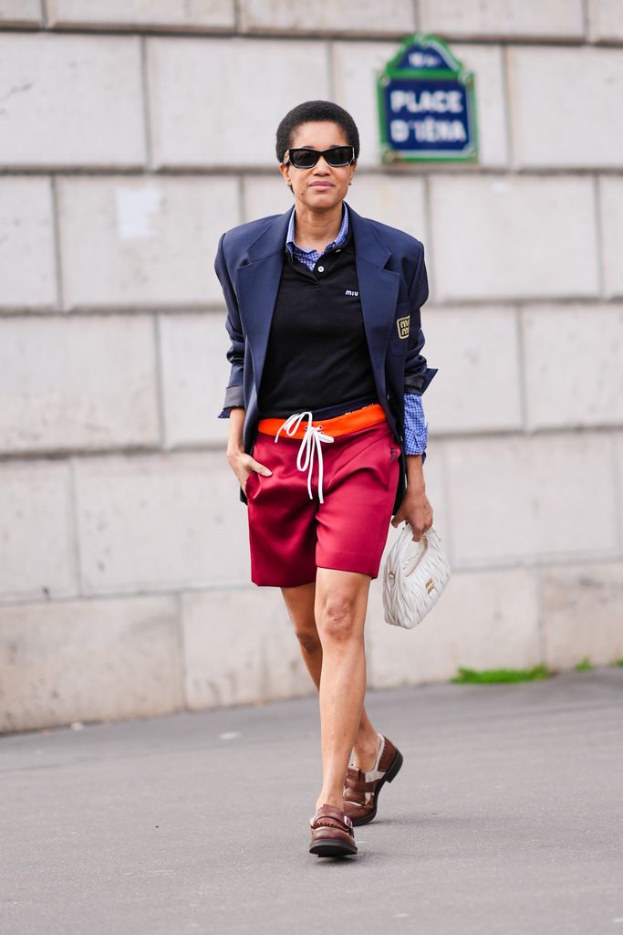 Tamu Mcpherson pairs her red Miu Miu long shorts with a polo top and Navy blazer outside the Miu Miu runway show in Paris.