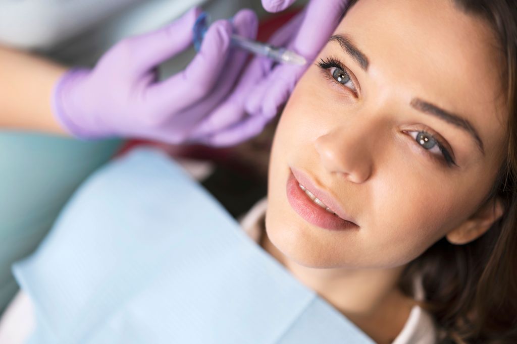 Young woman on a beauty treatment with the filler injection at the beauty clinic.