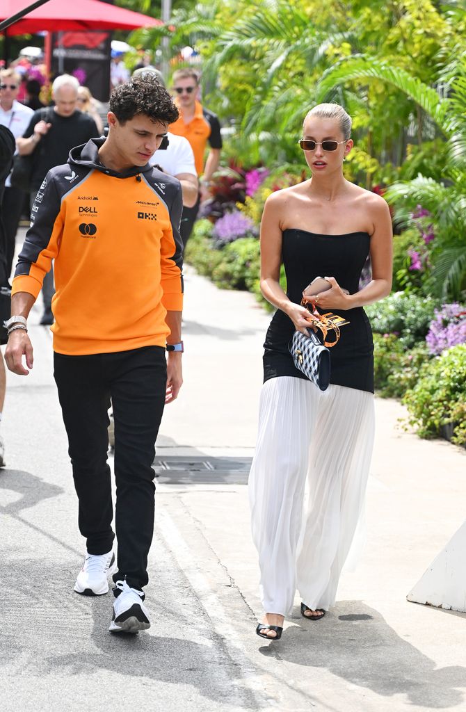 Lando Norris of Great Britain and McLaren and Margarida Corceiro arrive in the Paddock prior to final practice ahead of the F1 Grand Prix of Singapore at Marina Bay Street Circuit on October 04, 2025 in Singapore, Singapore. (Photo by Mark Sutton - Formula 1/Formula 1 via Getty Images)