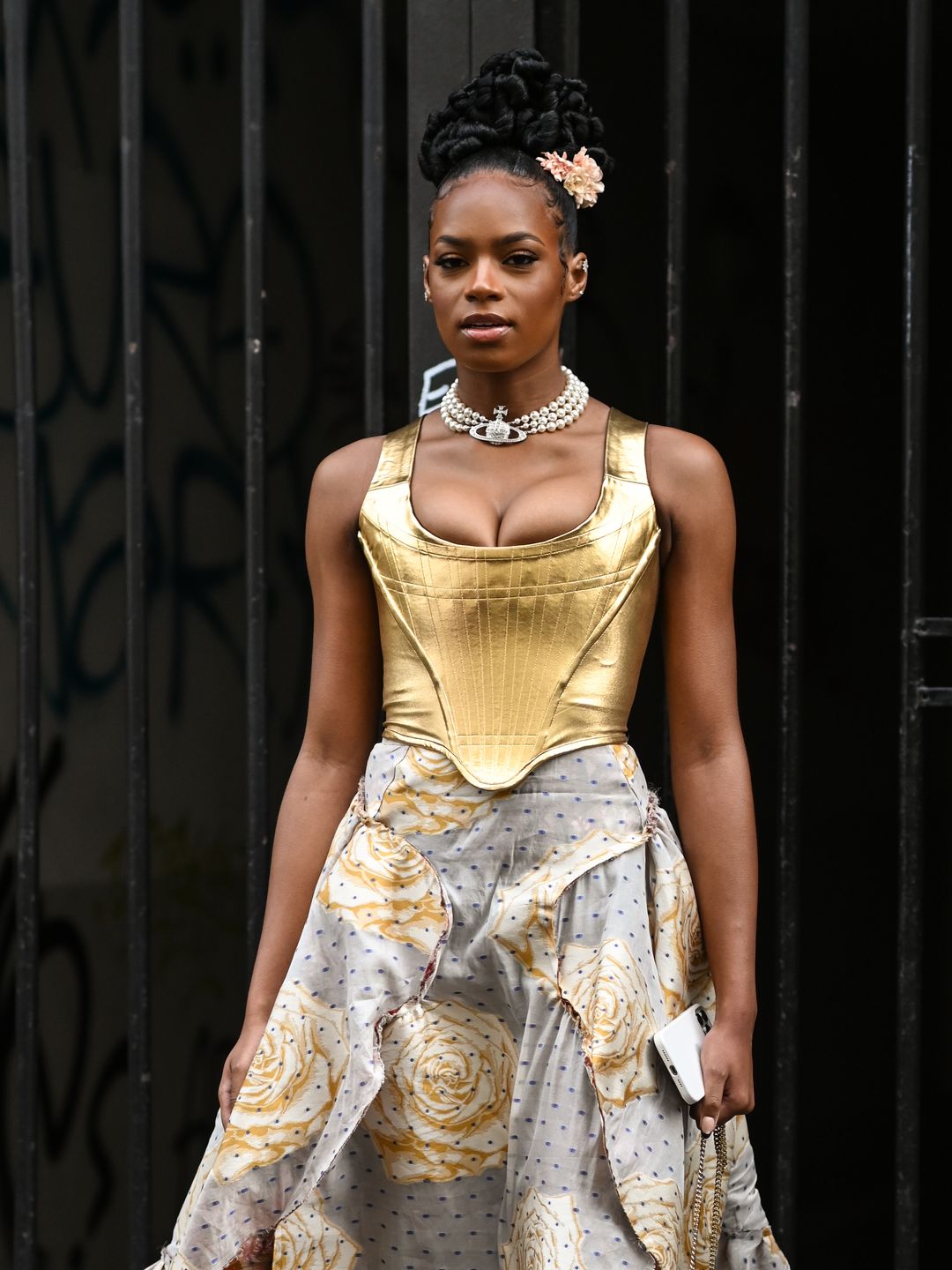 Didi Stone is seen wearing a gold Vivienne Westwood top and skirt and gold strapped heels outside the Vivienne Westwood show during Paris Fashion Week S/S 2022 on October 02, 2021 in Paris,