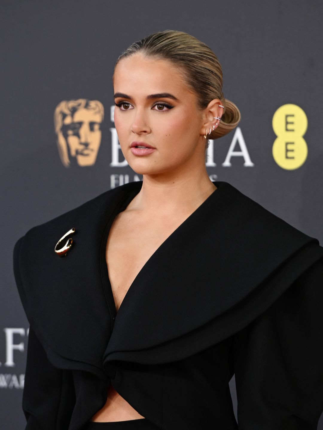 Molly-Mae Hague wearing a sculptural black dress and complimenting bun