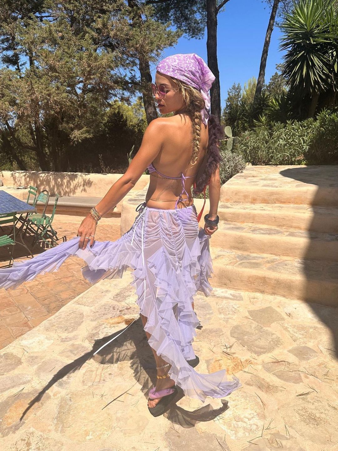 Rita Ora wearing a ruched bikini top with a sheer, ruffle skirt 