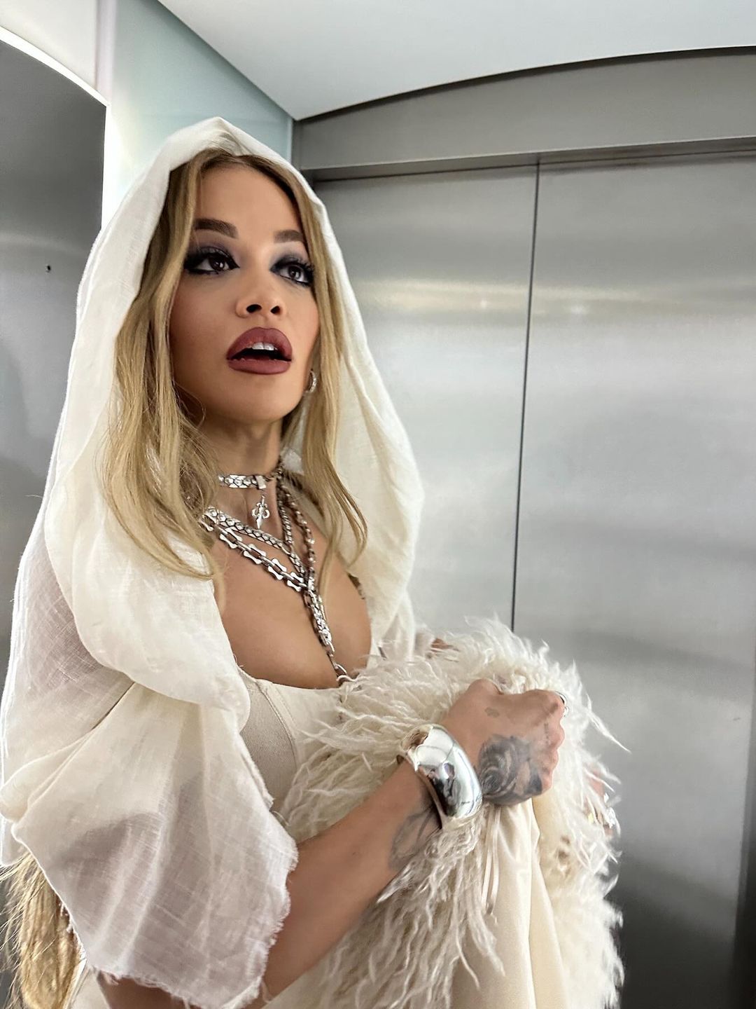 Rita Ora poses in a white corset, matching skirt, boots and a fluffy jacket on her Instagram 