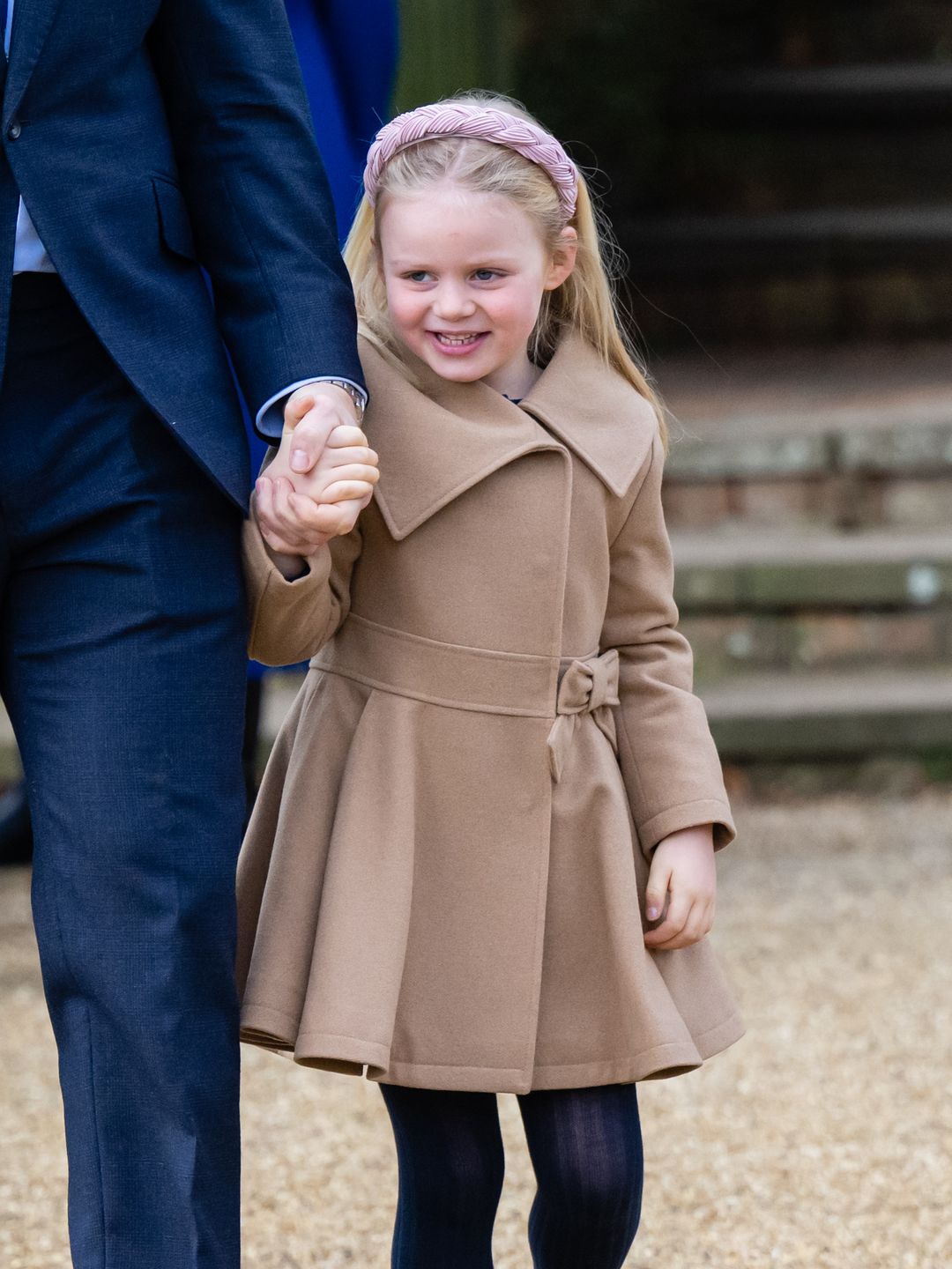 young girl walking to church in beige coat