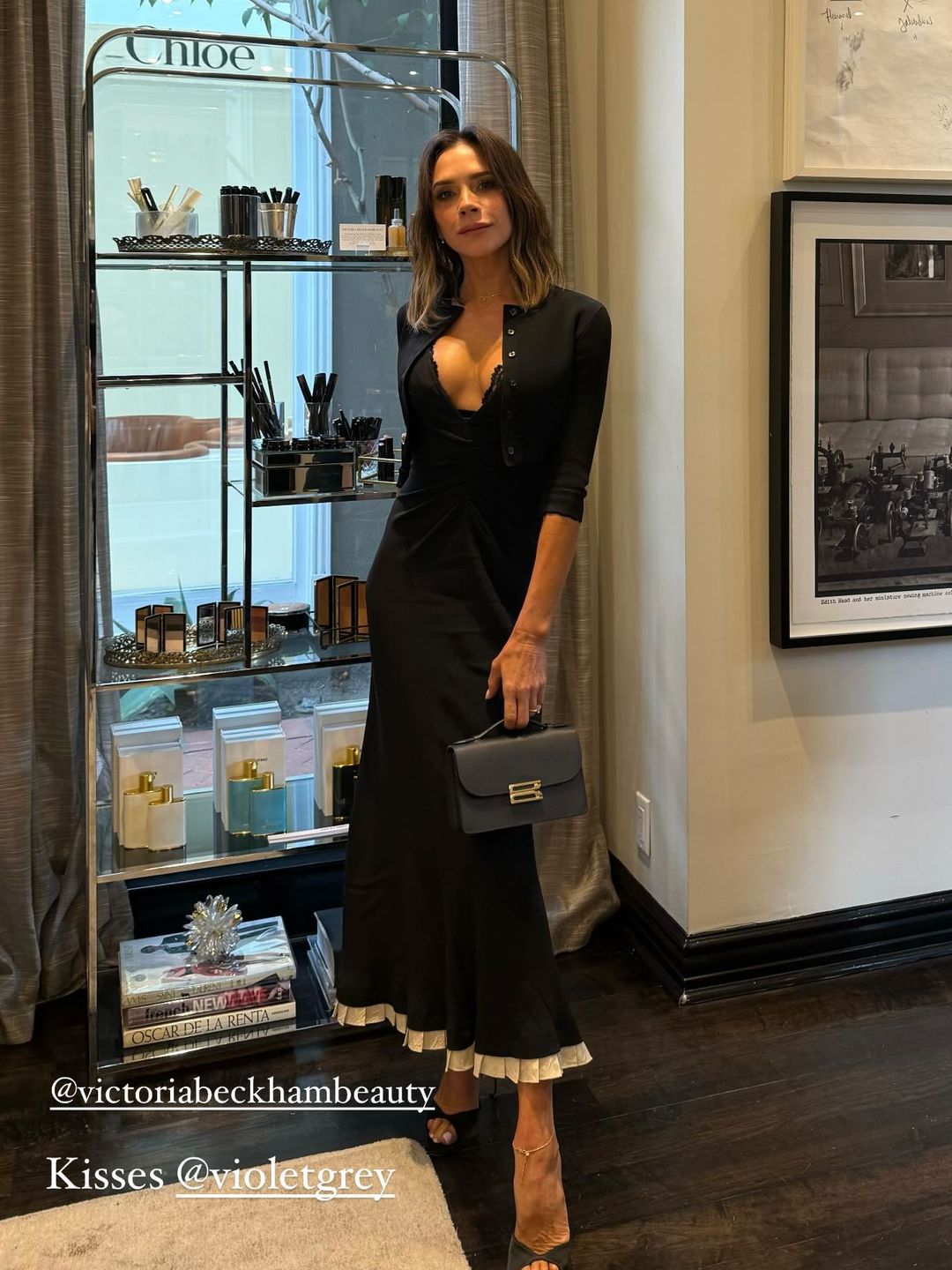 Victoria Beckham poses ina black dress while shopping for makeup in LA