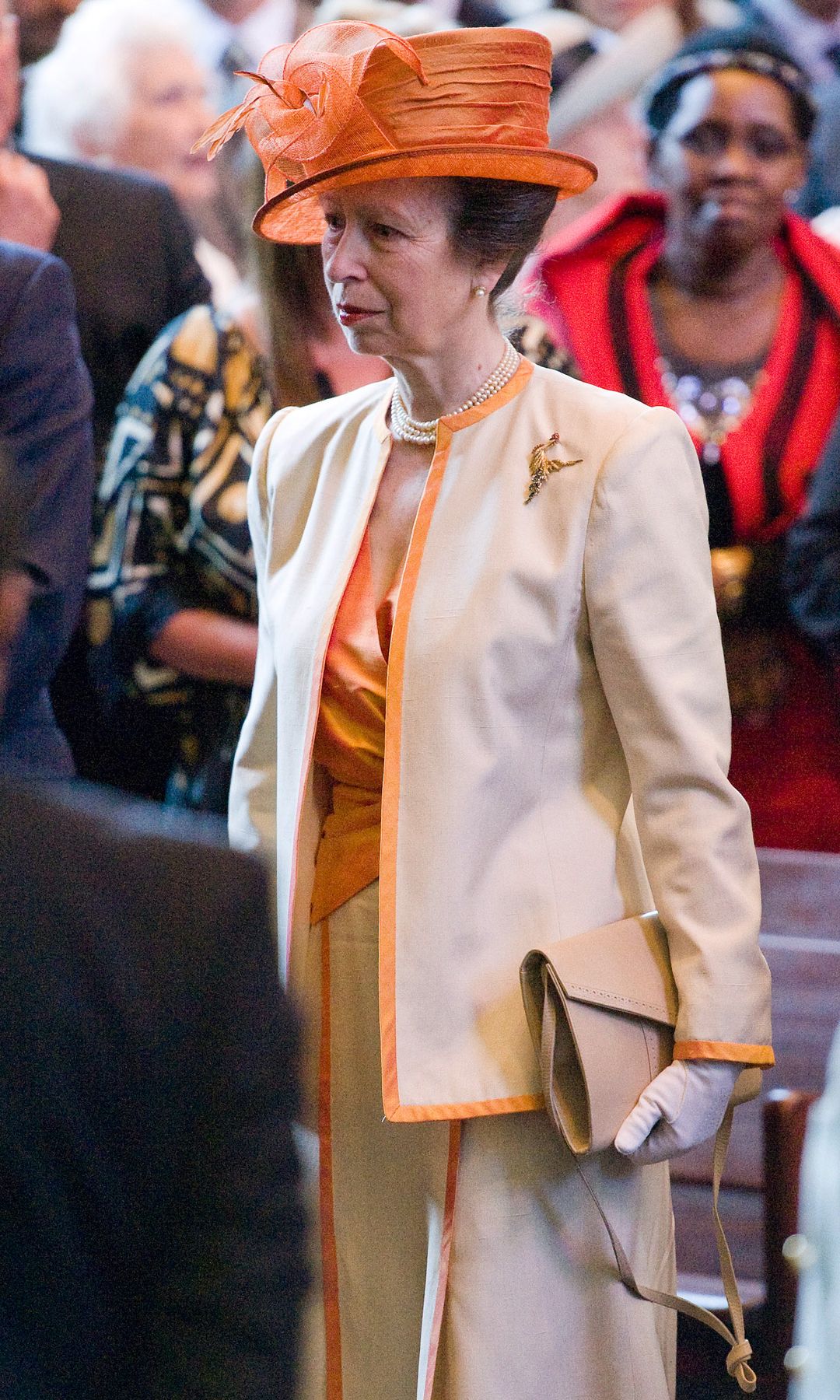 Princess Anne in an orange skirt suit and orange hat