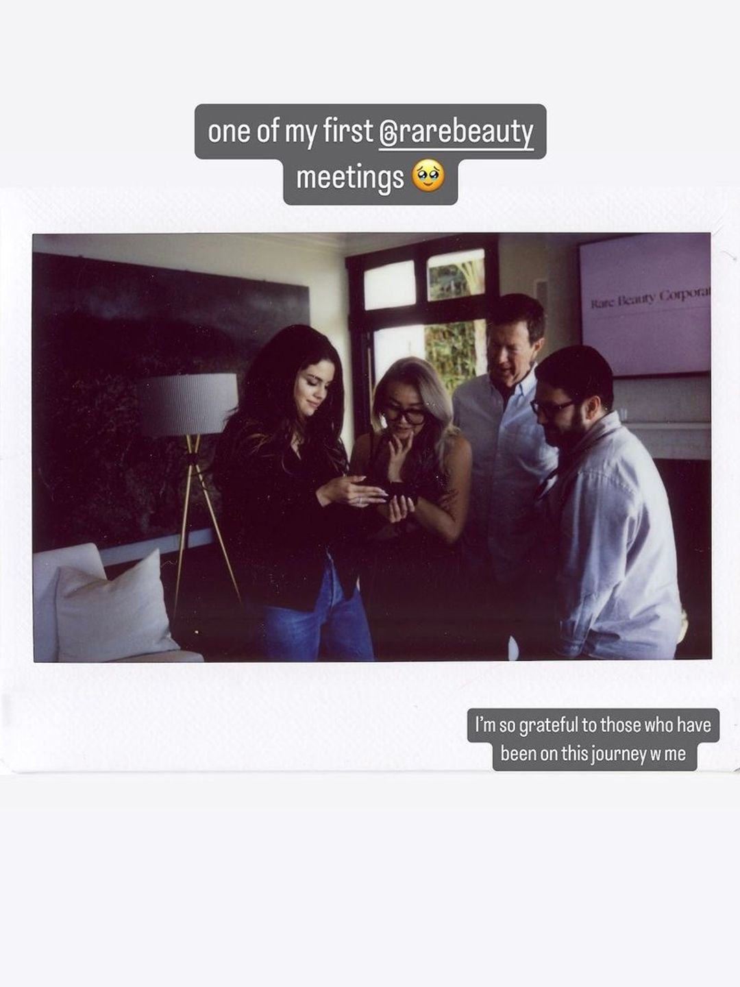Selena with her team looking at a phone 