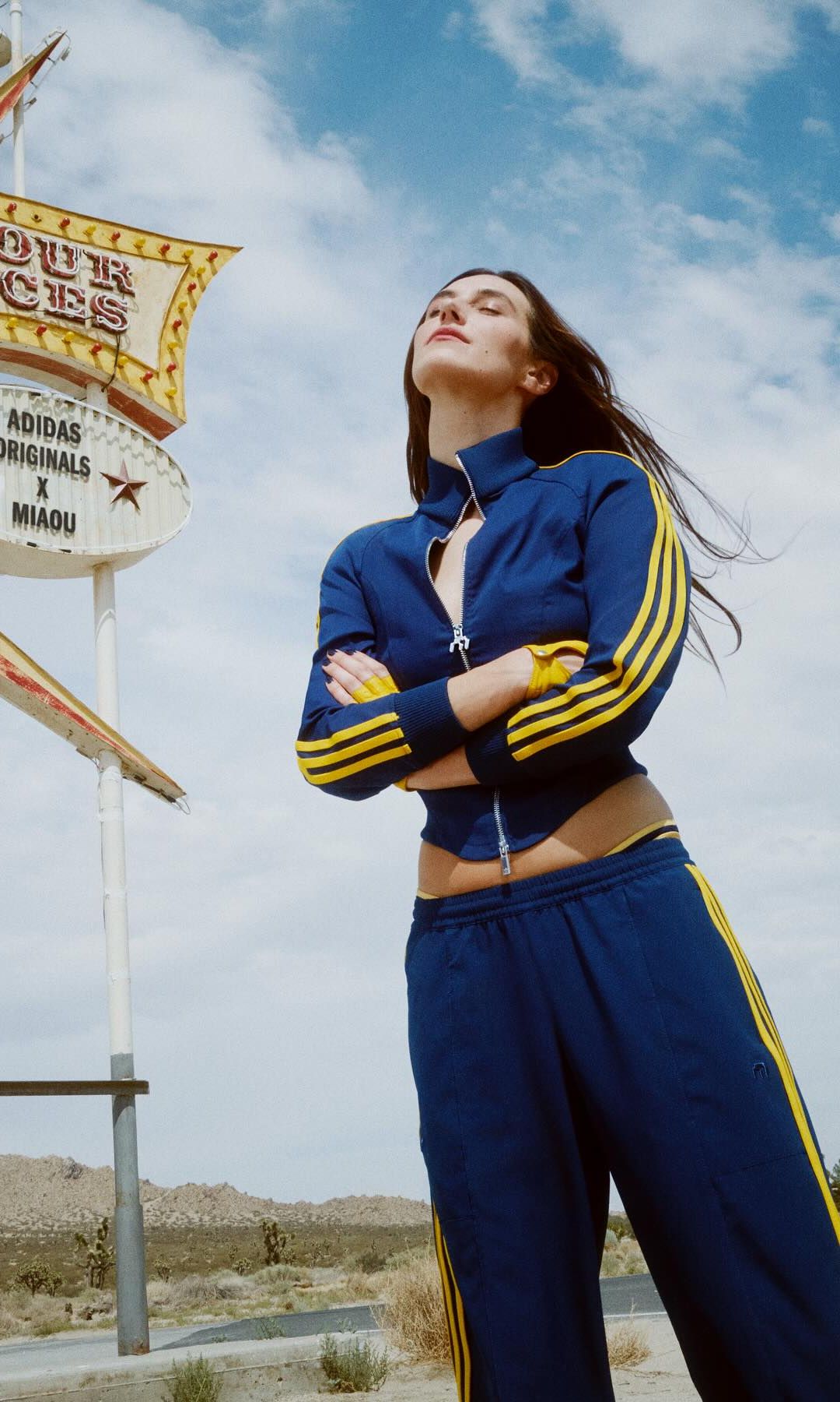 Devon Lee Carlson  wears a blue tracksuit with yellow stripes 