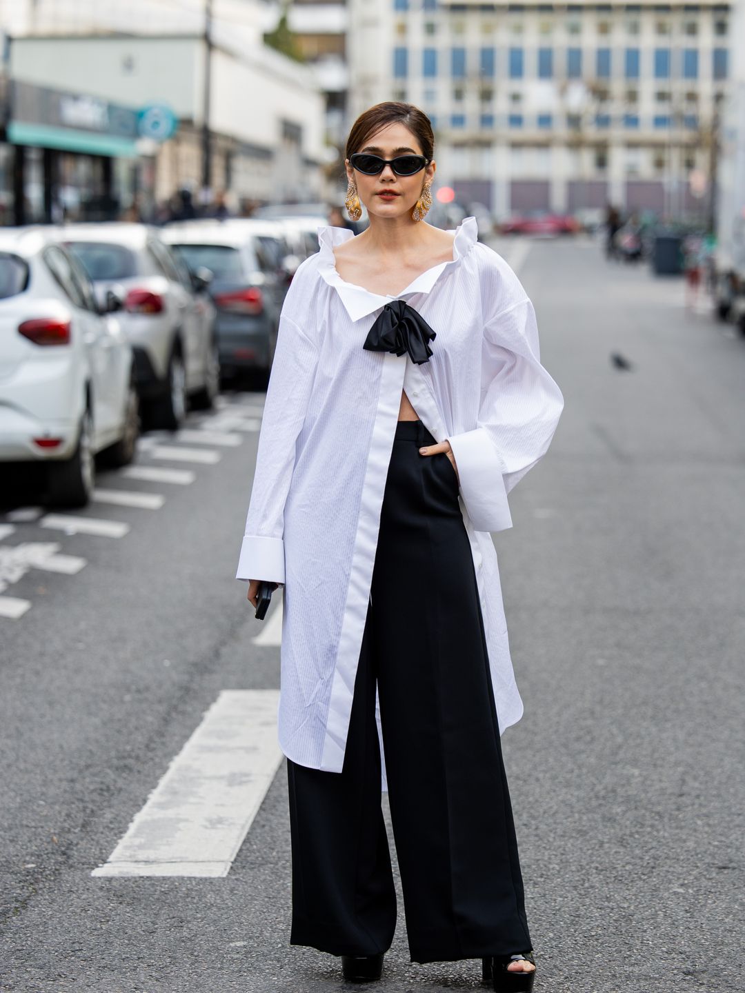 Araya A. Hargate wears white oversized button shirt, black pants, platform sandals wears outside Viktor&Rolf during the Haute Couture Spring/Summer 2024 