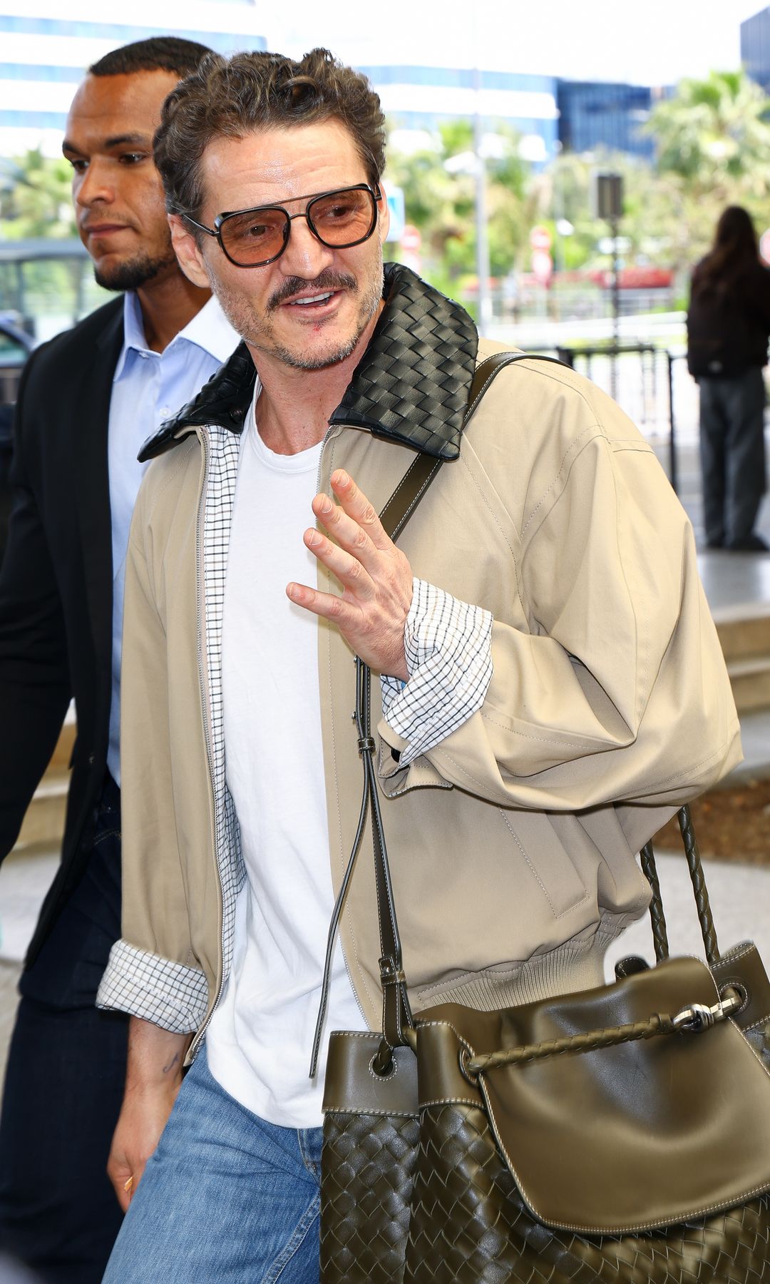 Pedro Pascal waving while leaving an airport