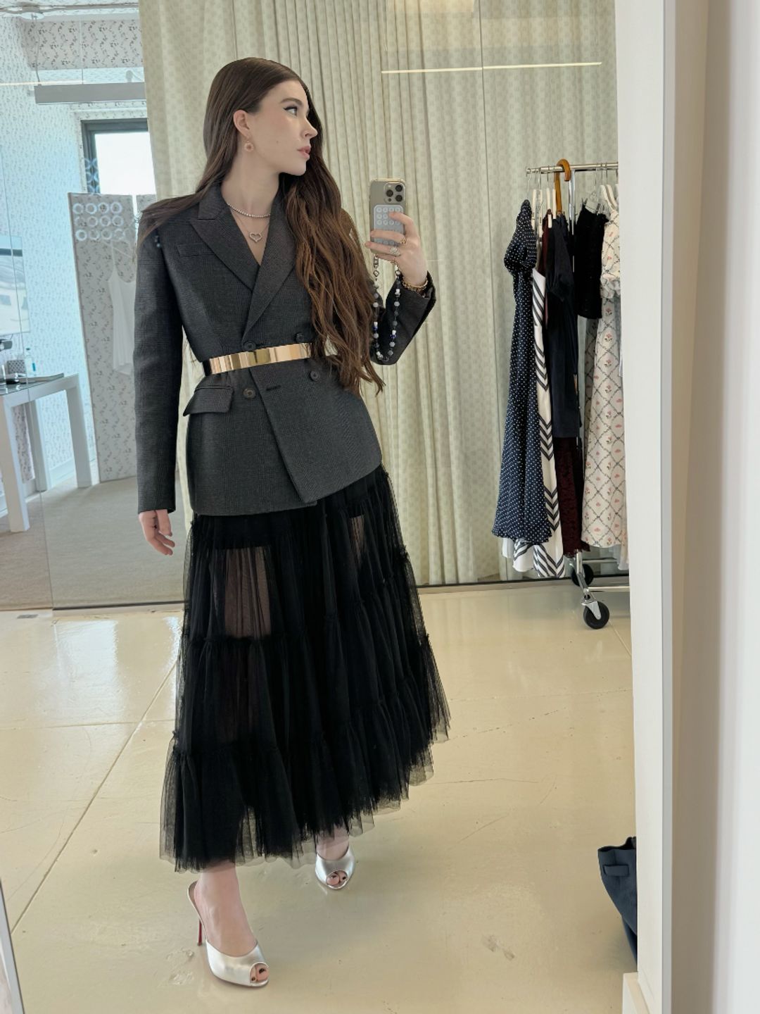 Nell Diamond poses in a grey blazer and tulle black skirt 