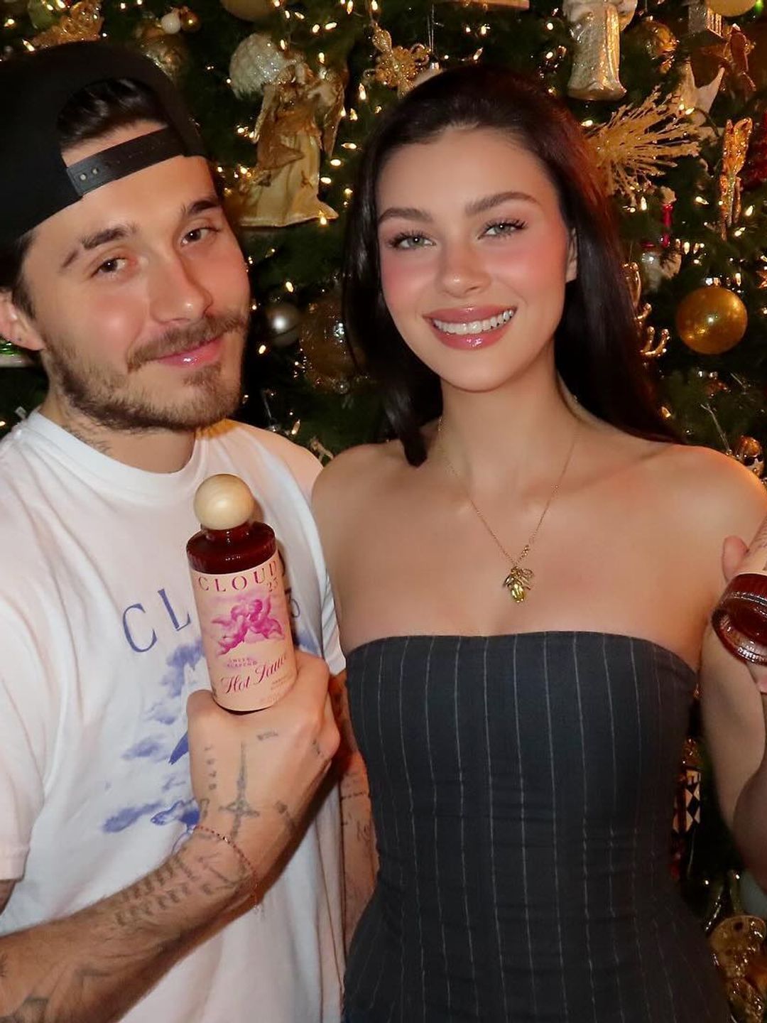 Nicola and Brooklyn Beckham pose in front of a Christmas tree