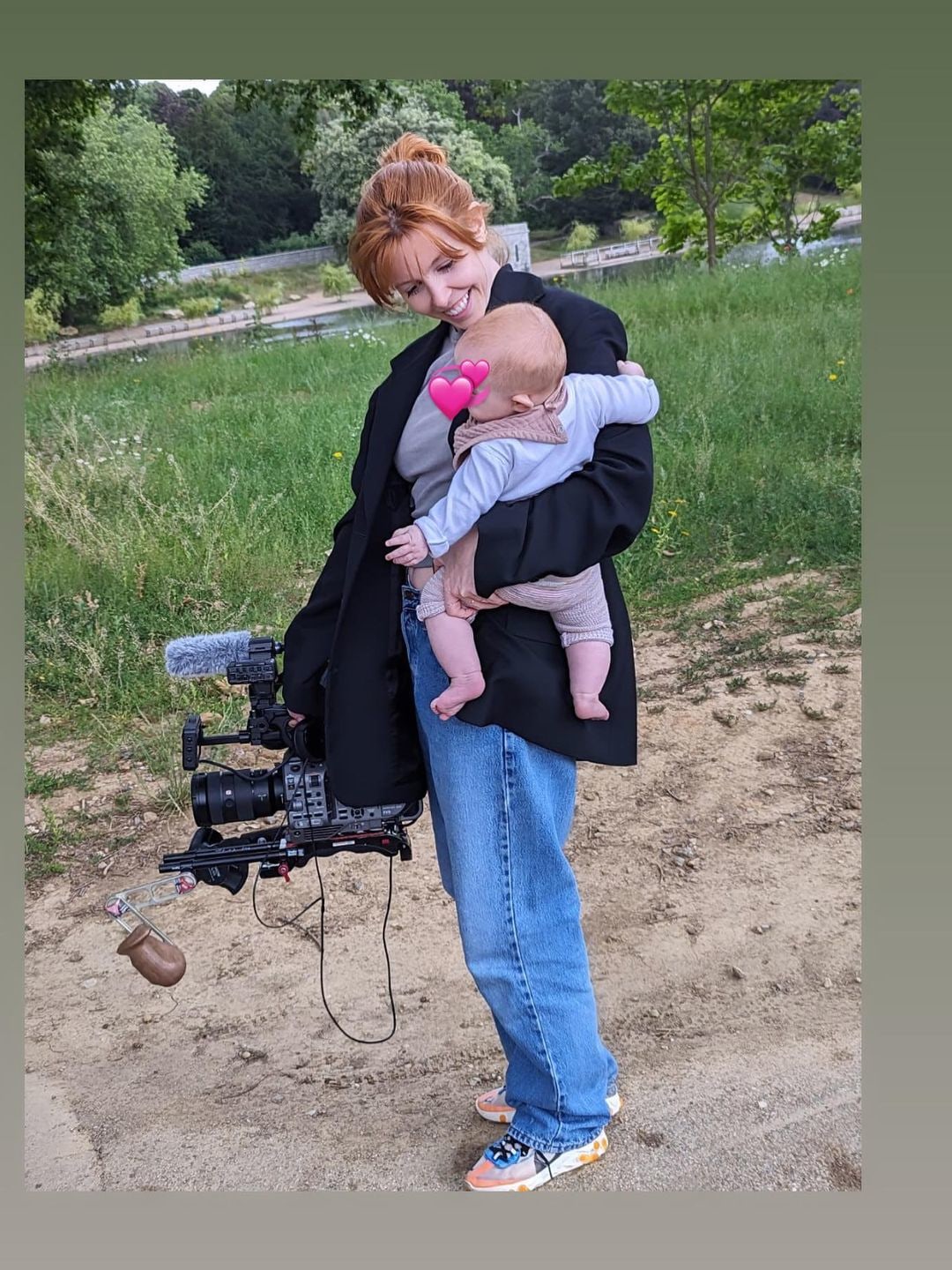 stacey dooley holding baby with camera 