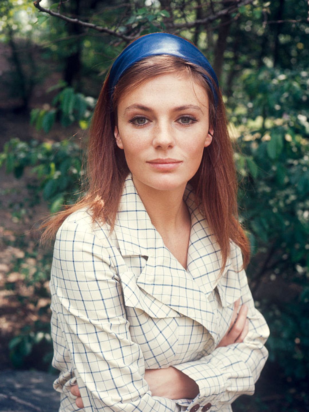 Jacqueline Bisset pictured in 1970. She is wearing a blue headband and a checked jacket. 