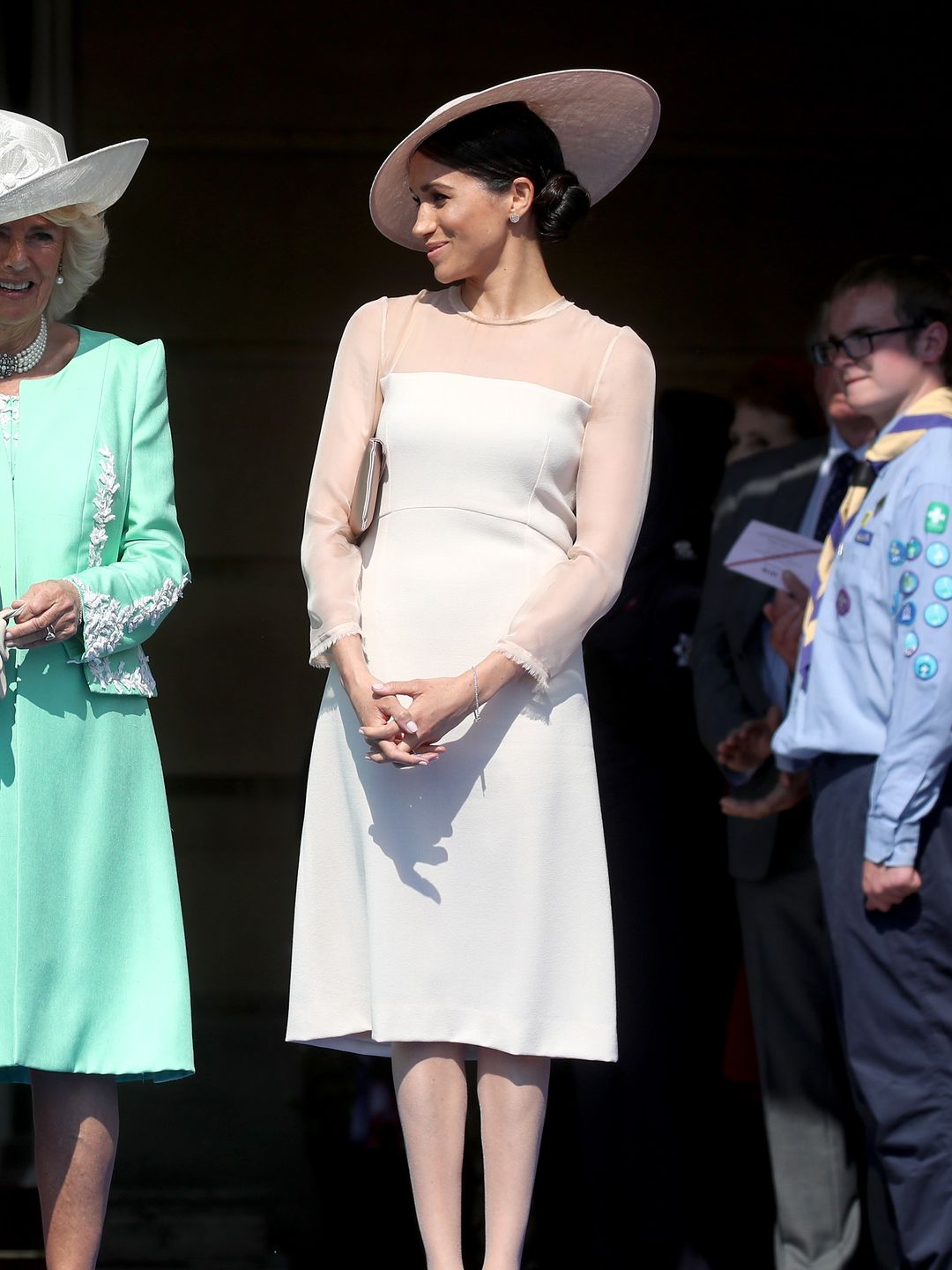 Queen Camilla standing with Meghan Markle in tights
