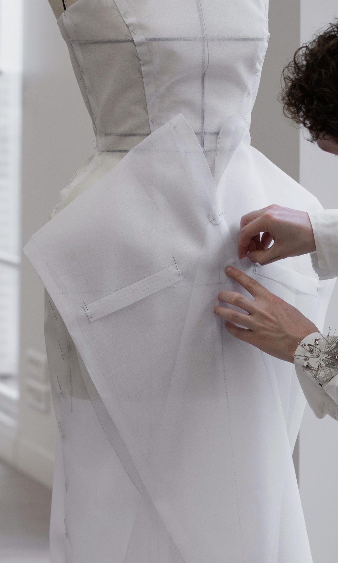 dior gown being pinned and pattern cut