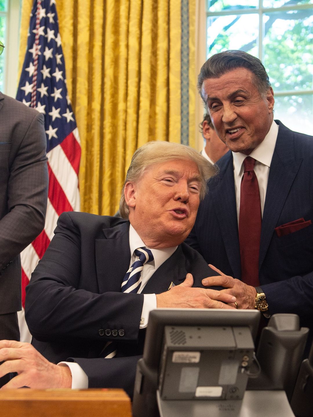 US President Donald Trump jokes with actor Sylvester Stallone(R) before signing a posthumous pardon for former world champion boxer Jack Johnson