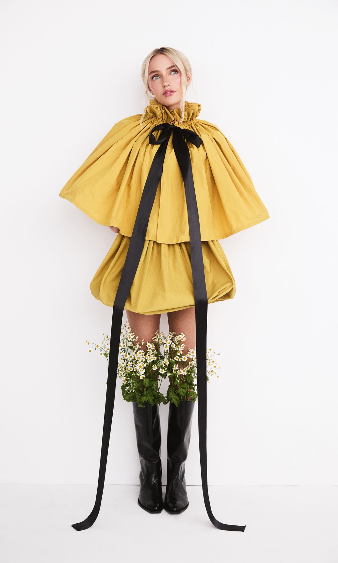 Dress: Venus Mini Puff Dress, £525, g.AMOUR, Cape: Proc Cropped Cape, £360, g.AMOUR, Boots: Charlotte Boots, £650, Pleiades.