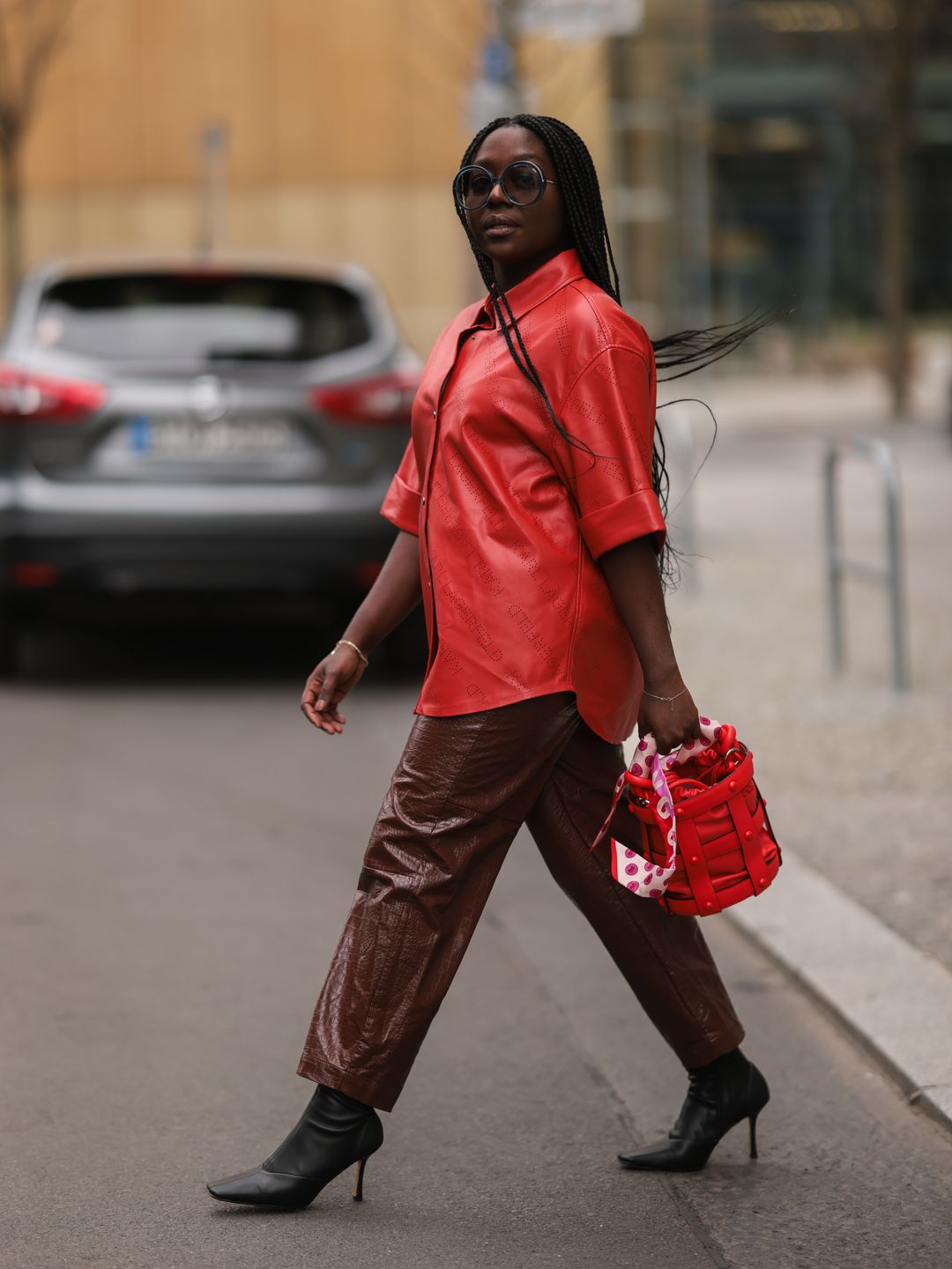 Lois Opoku wears a red shirt and straight-leg leather trousers 
