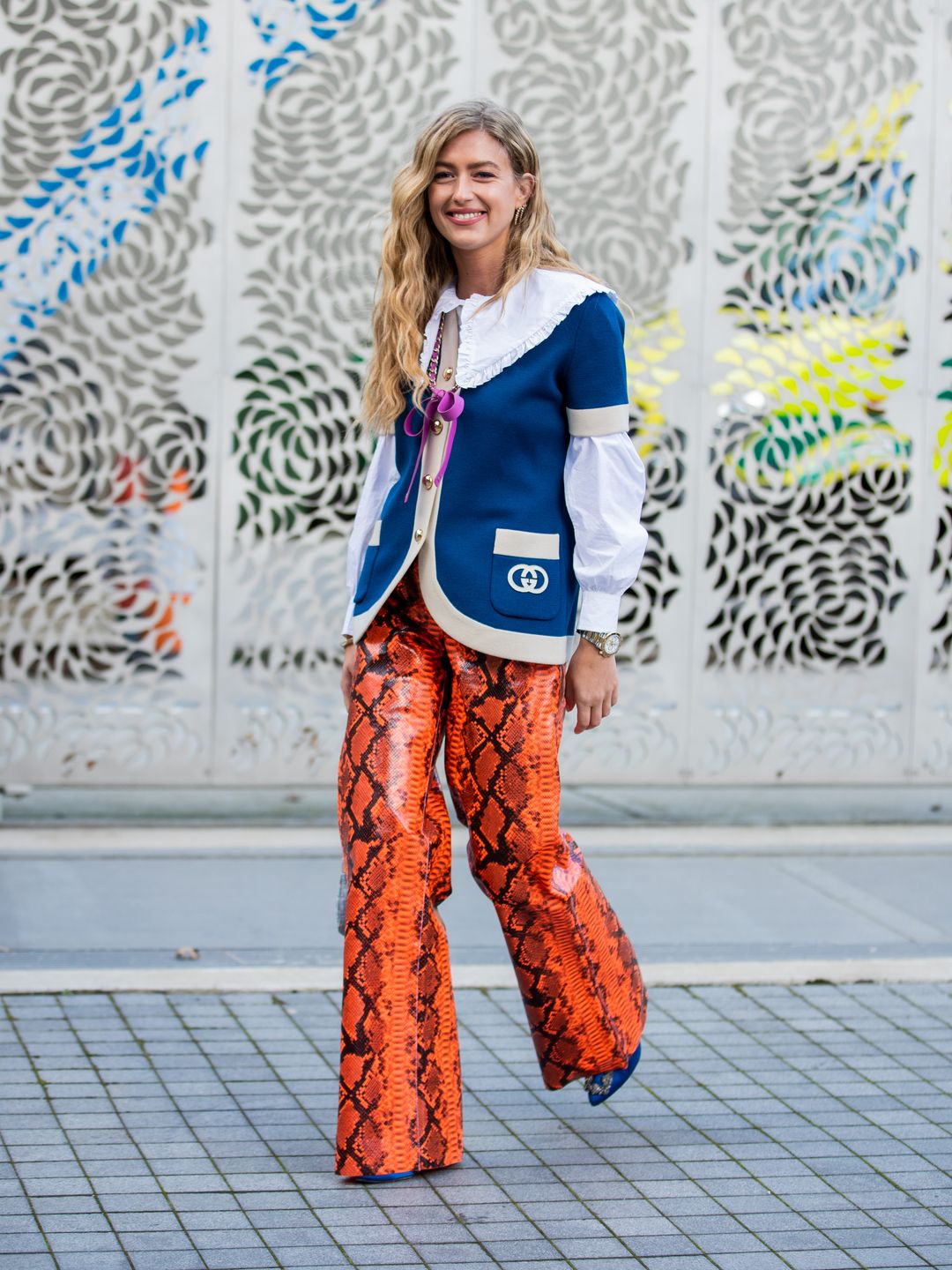 Emili Sindlev wears orange snake print leather trousers and a frill collar blouse 