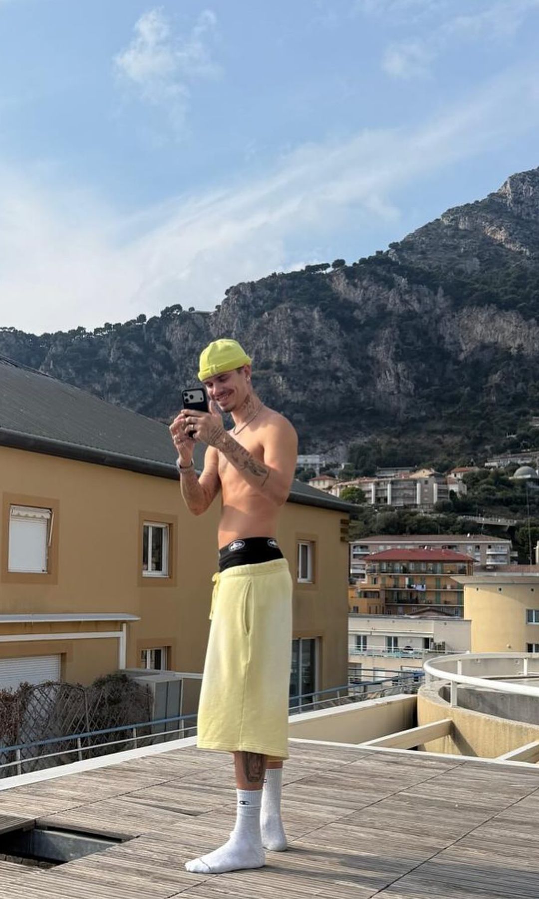 Romeo Beckham was snapped taking a picture in a yellow beanie and sweat shorts