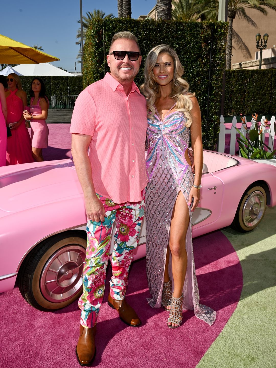 Christina and James smiling at the exclusive event, a pink Barbie car behind them