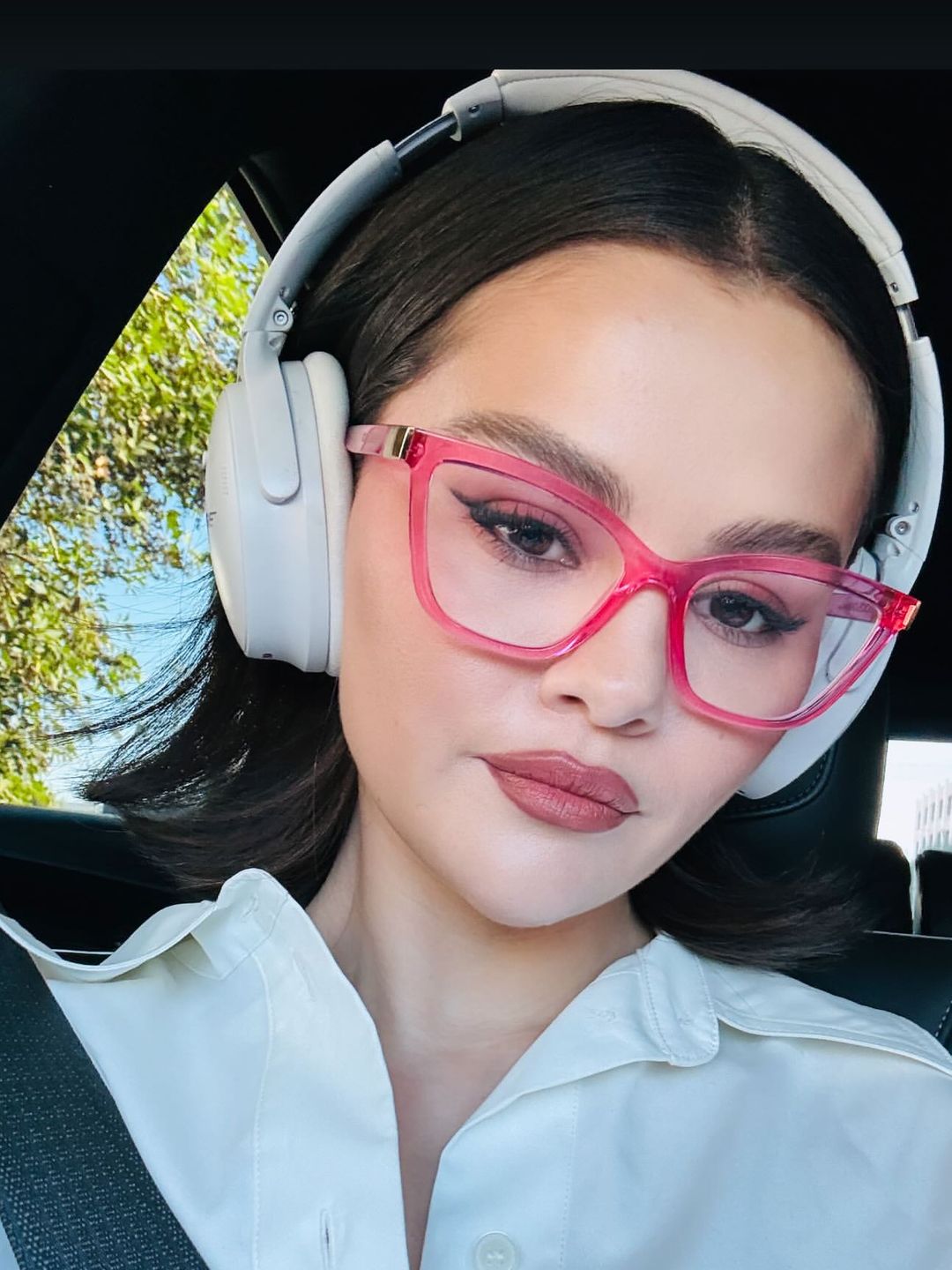 Selena Gomez shares a selfie of herself wearing pink glasses in a car