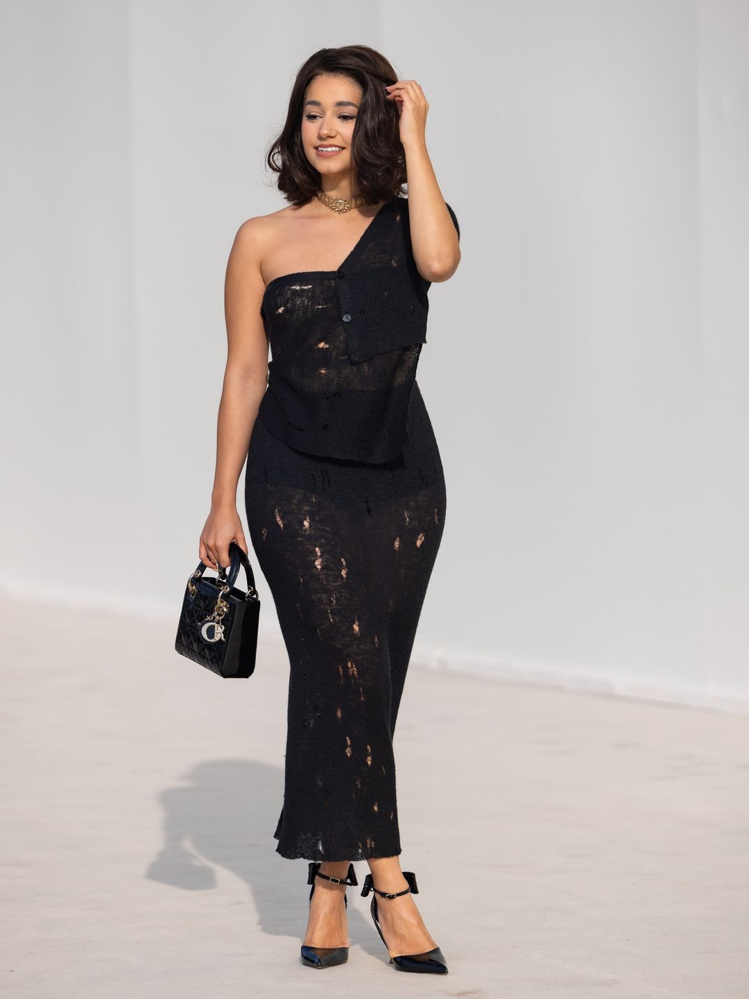 Lena Mahfouf attends the Christian Dior show in a black knit dress and heels