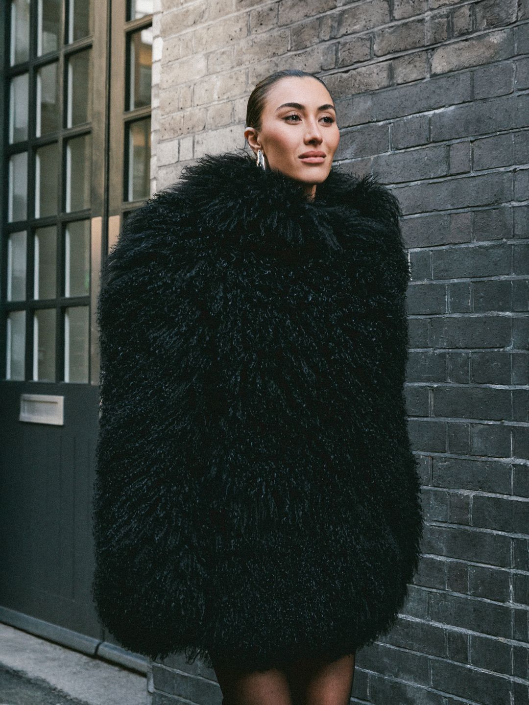 Sophie Habboo for H! Fashion wearing a black fluffy coat and slick back hairstyle